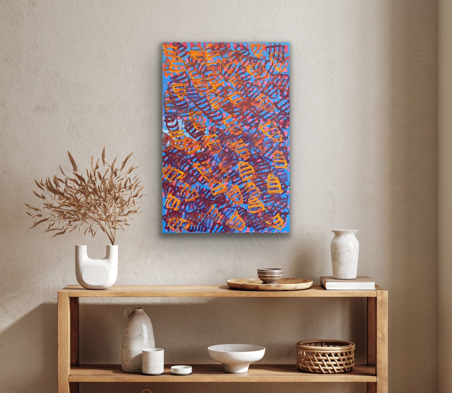 A painting by Emily Pwerle hanging on a textured wall.