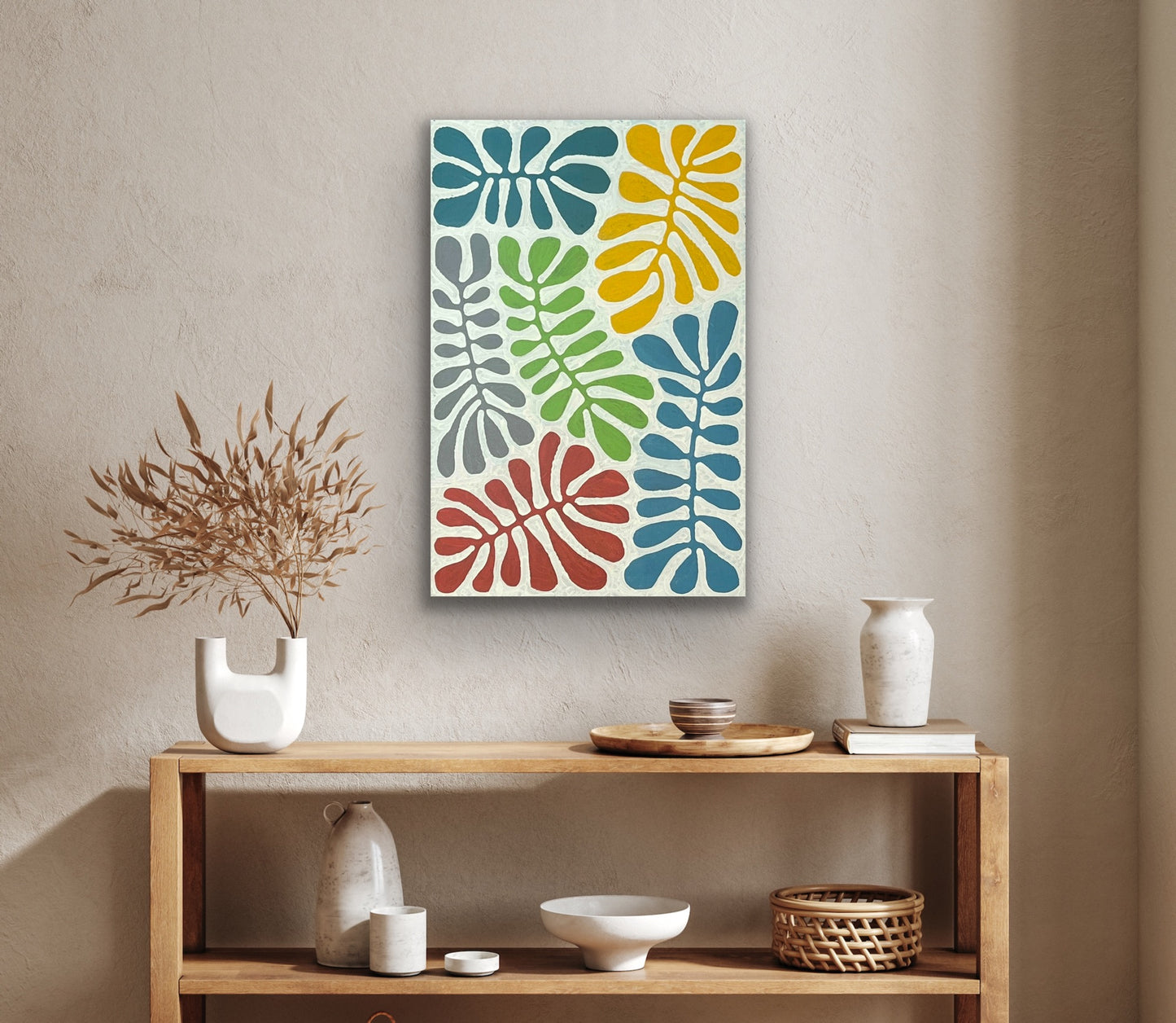 A painting by Mitjili Naparrula on the wall above a wooden bookshelf with various décor objects.