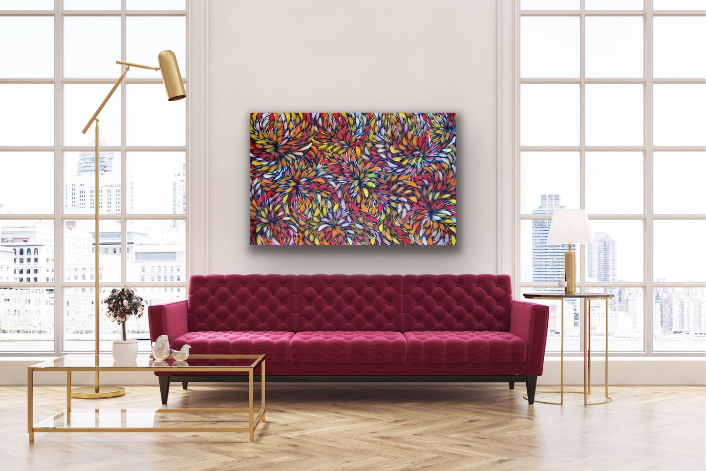 A painting by Selina Numina Kamprina hanging above a modern luxe red couch with cofee table and other décor items.