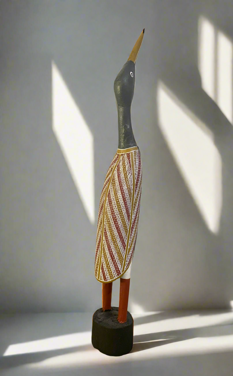 A wooden Ibis carving of a bird by Leon Ali with aboriginal rarrk patterned wings