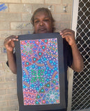 Anna Tilmouth Napangardi holding her 'Atnyerlenge (Native Fuchsia)' painting 48x26cm