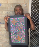 Anna Tilmouth Napangardi holding her 'Atnyerlenge (Native Fuchsia)' painting 48x26cm