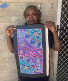 Anna Tilmouth Napangardi holding her 'Atnyerlenge (Native Fuchsia)' painting 48x26cm