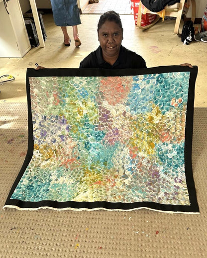 Belinda Golder Kngwarreye holding her 'Bush Plum painting. 