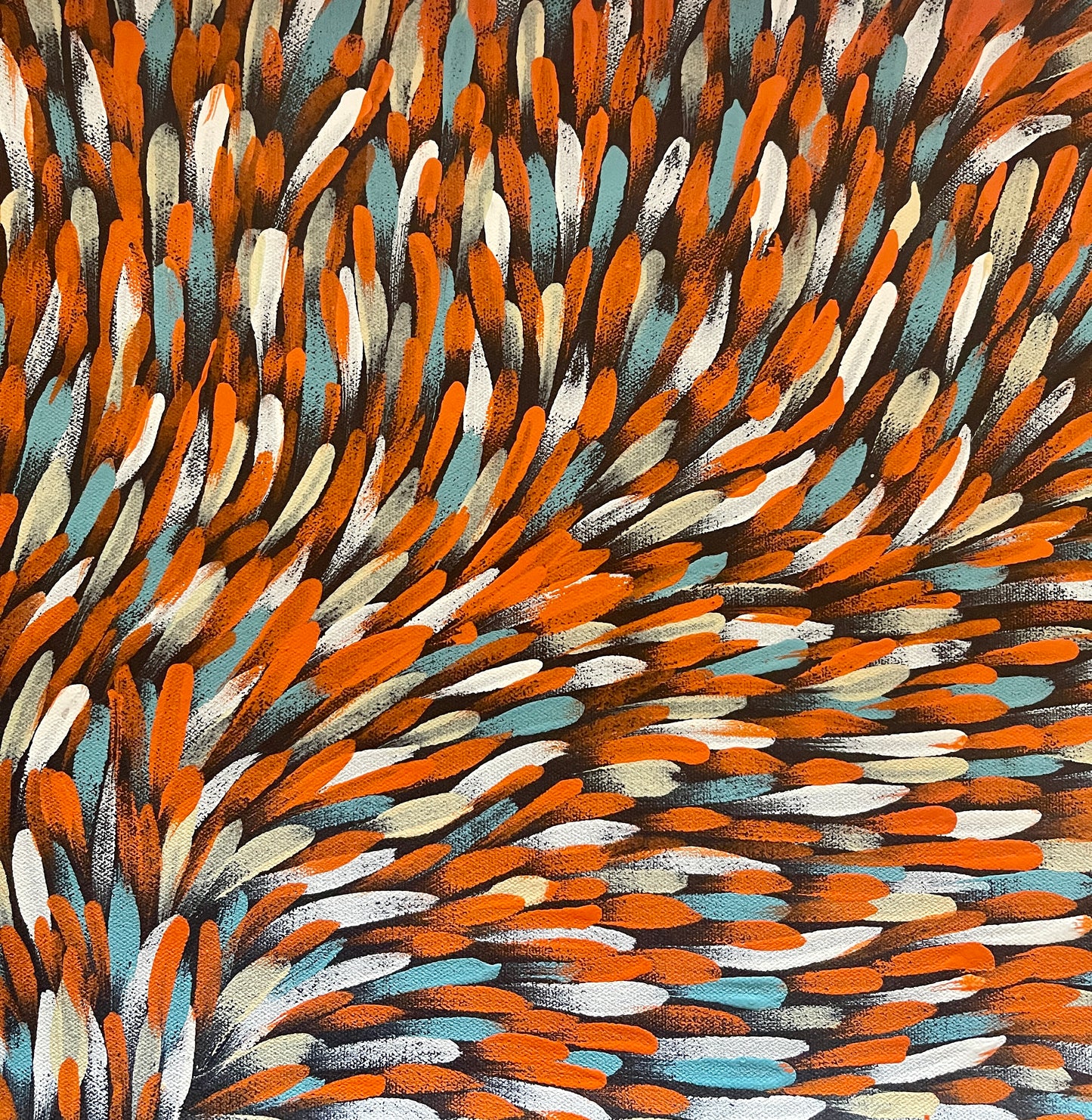 An extreme close-up of a painting by Gloria Petyarre featuring a pattern of Bush Medicine Leaves in orange, light blue and white on a primed linen canvas.