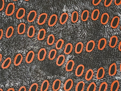 Close-up of a painting by Ngoia Pollard Napalptjarri. Red circles on a white dotted black background.
