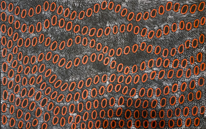 A painting by Ngoia Pollard Napalptjarri showing red oval shapes on a white dotted black background.