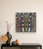 A 45x45cm painting by Colleen Wallace hanging on a wall above a console table with decorative items.