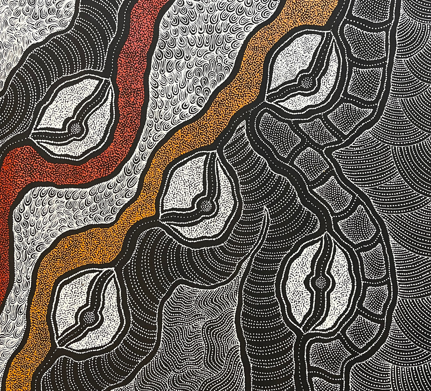 Close-up of a painting by Delvine Pitjara with intricate patterns in red, orange and white dots on black.