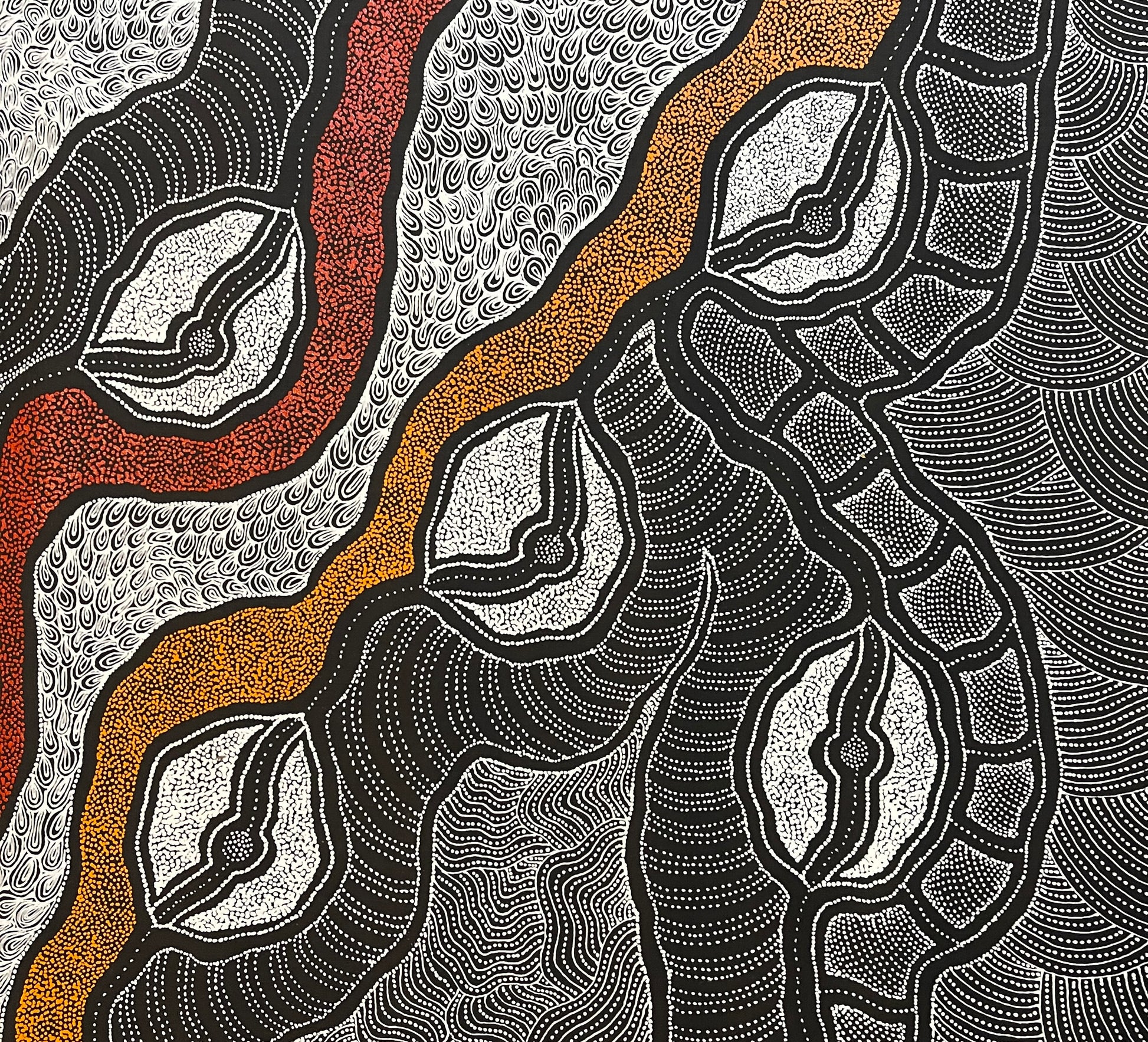 Close-up of a painting by Delvine Pitjara with intricate patterns in red, orange and white dots on black.