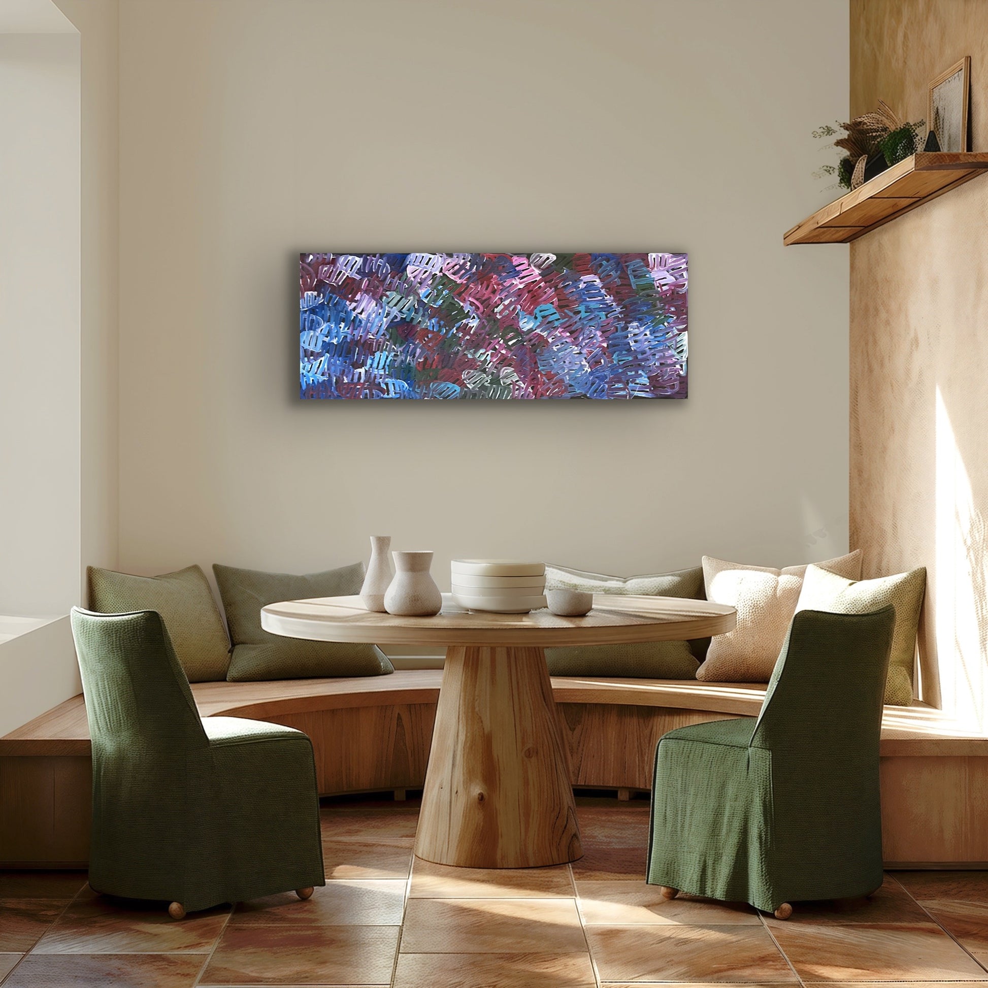 A painting by Emily Pwerle in a modern dining setting with green dining chairs and wooden table.