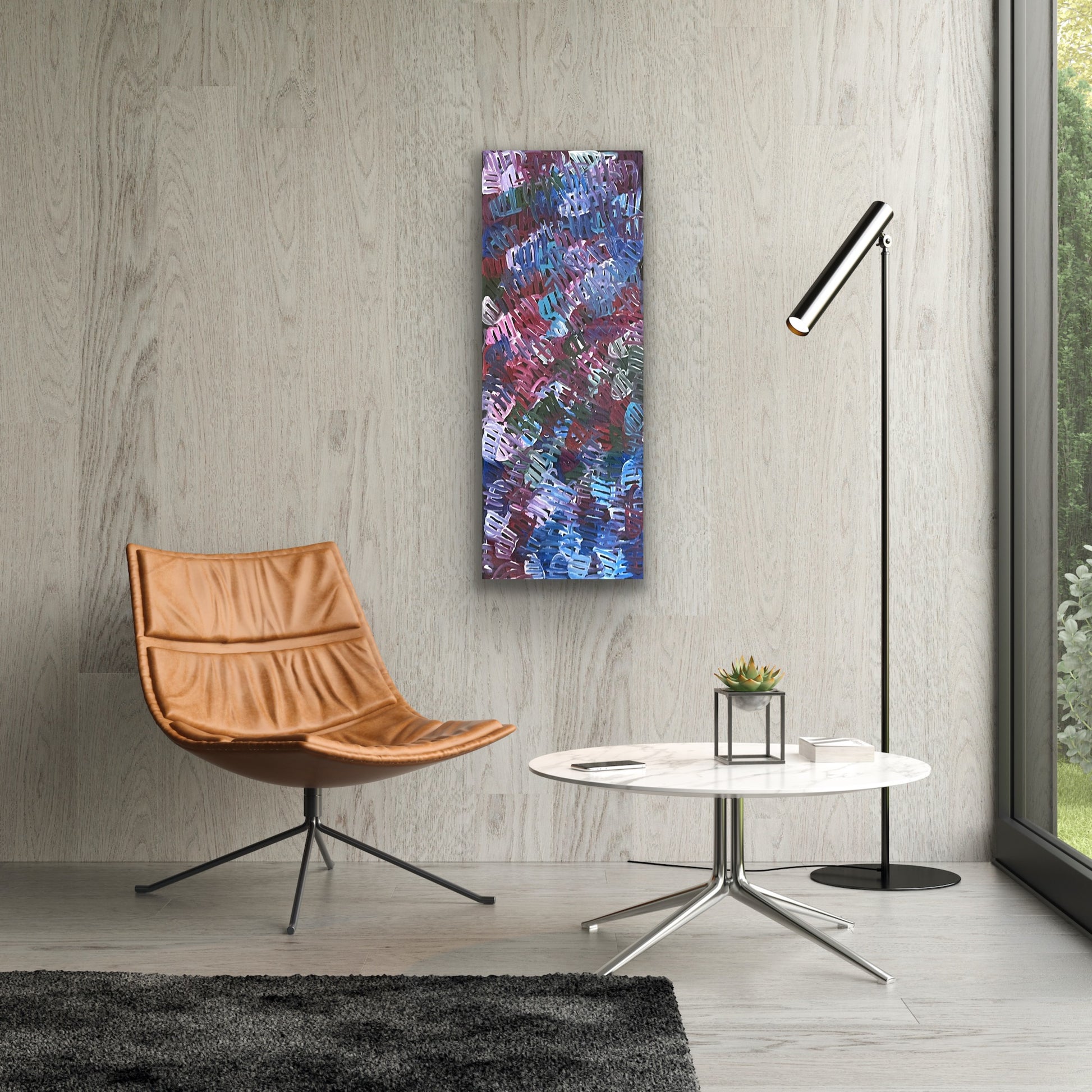 A painting by Emily Pwerle in a modern setting with brown chair and marble coffee table.
