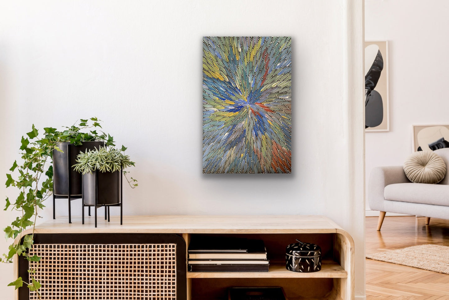A colourful painting by Bernadine Johnson Kemarre with a radiant pattern in shades of blue, green, yellow, and red, representing Bush Medicine Leaves.