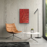 A painting by Bambatu Napangardi hanging on a wall above a brown chair, white marble coffee table and lamp.
