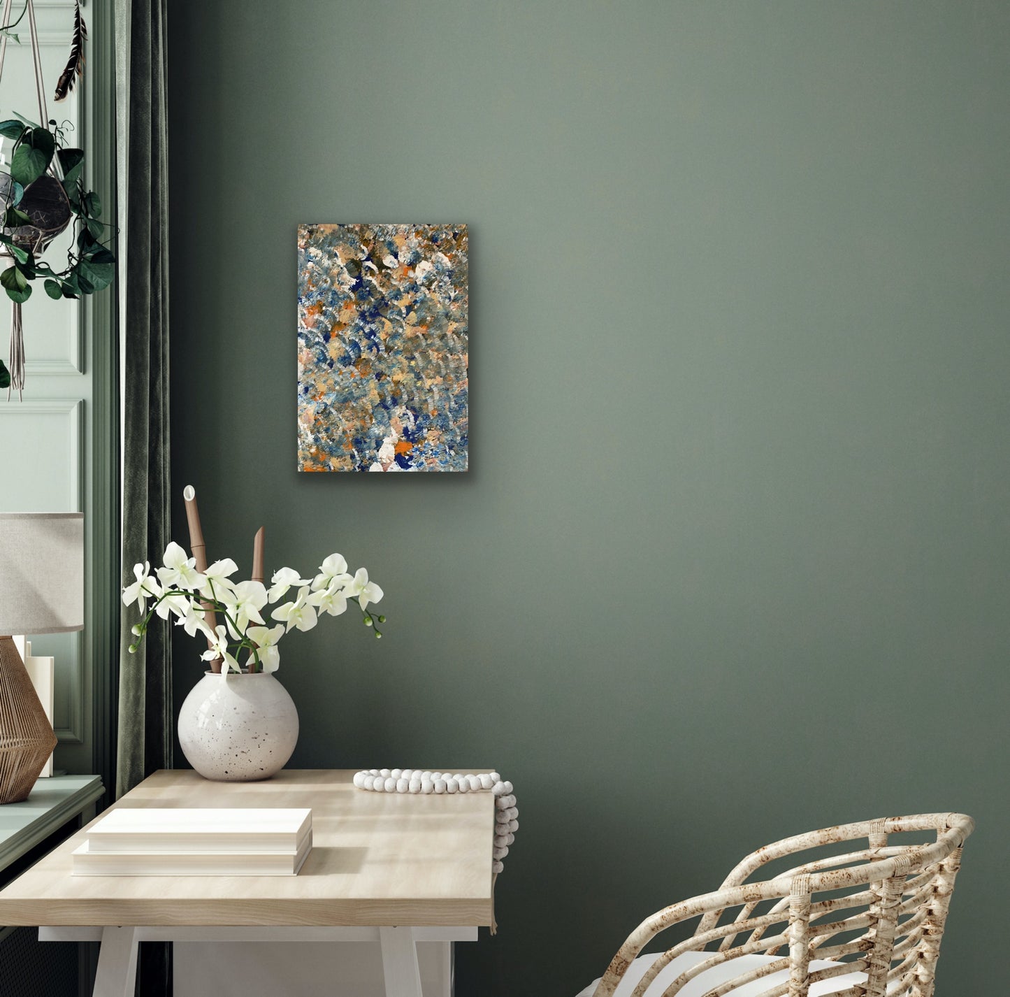 A painting by Belinda Golder Kngwarreye depicting bush plum dreaming hanging on a green wall above a table, vase of flowers and desk chair.