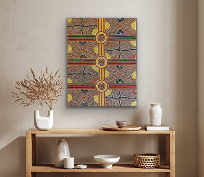 A painting by Kevin Bird Mpetyane depicting mulga seed dreaming hanging on a beige wall above a wooden console table.