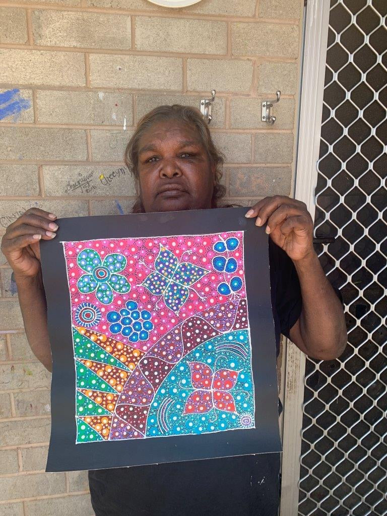 Anna Tilmouth Napangardi holding her 'Atnyerlenge (Native Fuchsia)' painting 35x31cm