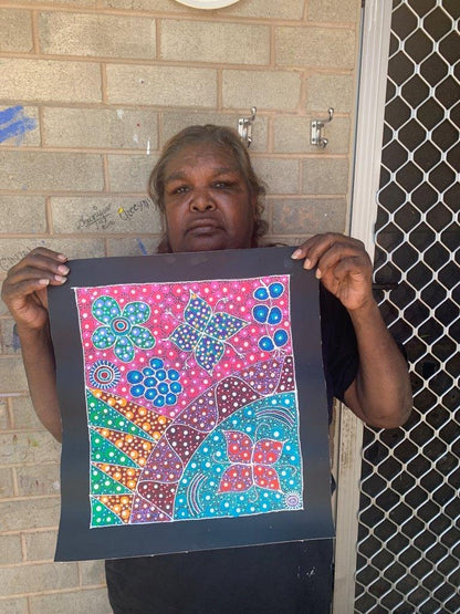 Anna Tilmouth Napangardi holding her 'Atnyerlenge (Native Fuchsia)' painting 35x31cm