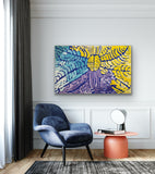 A painting by Lorna Fencer Napurrula depicting yarla or bush potato dreaming hanging in a modern interior with a blue armchair and orange side table.