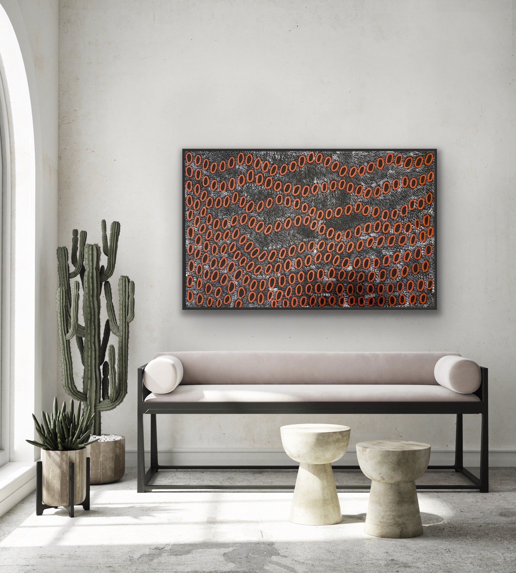 A painting by Ngoia Pollard Napalptjarri hanging above a modern bench seat, and decorative items.