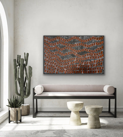 A painting by Ngoia Pollard Napalptjarri hanging above a modern bench seat, and decorative items.