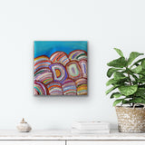 A 30x30cm painting by Debbie Beasley, representing bush medicine plants and flowers on a white console table with decor items and plant.