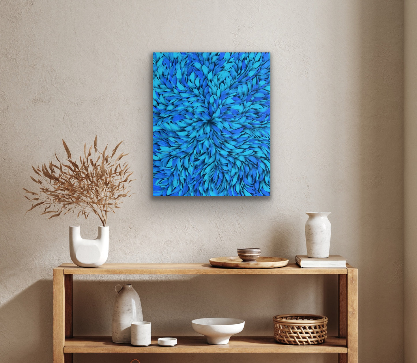 A blue painting by Selina Numina hanging on a wall above a wooden console table with decorative items.