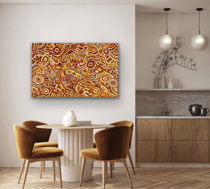 A painting by Betty Club Mbitjana hanging on a wall above a modern dining table and a kitchen.