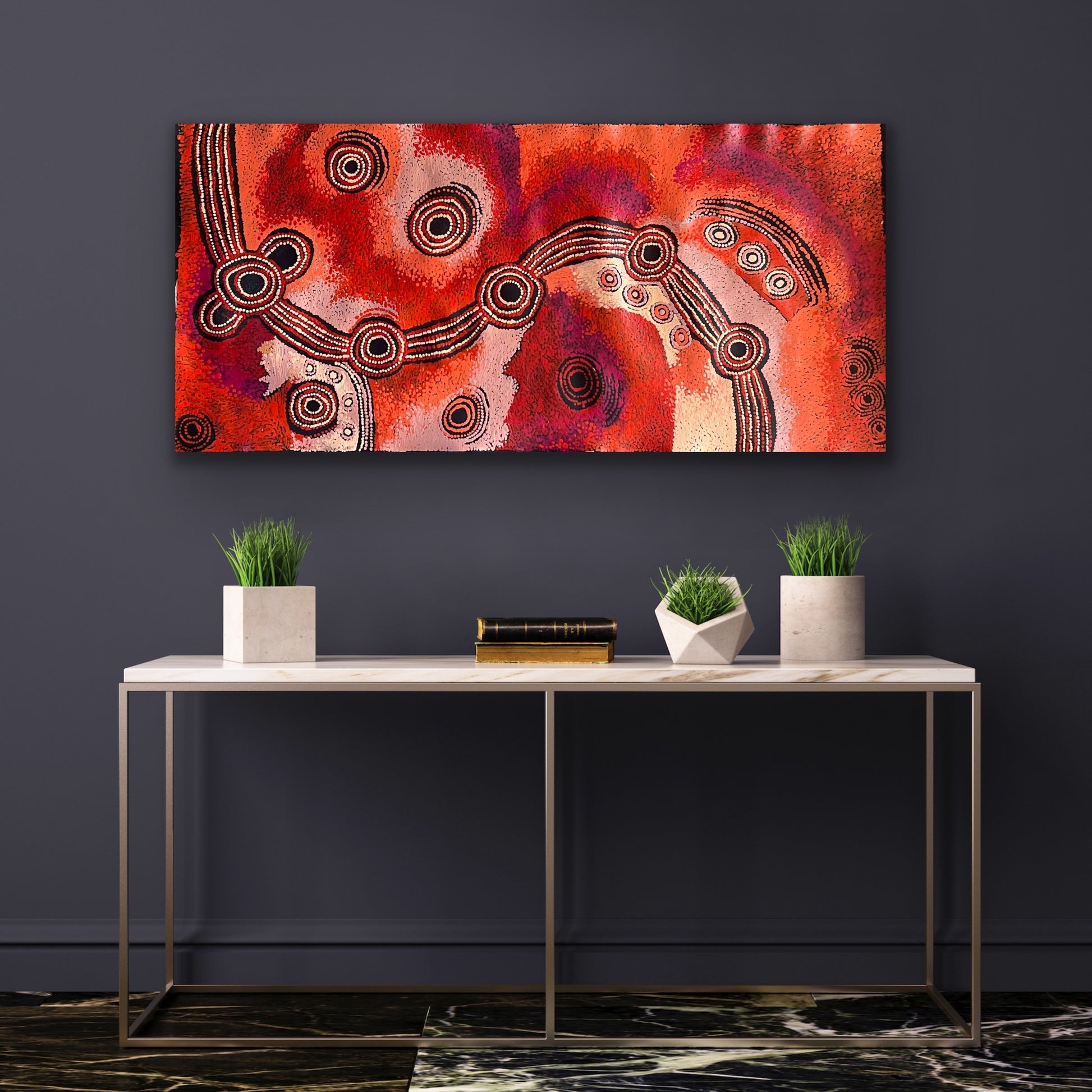 A painting by Teresa Baker featuring abstract geometric patterns with predominantly red and black colors, representing the creation story of Minyma Malilu Tjukurrpa.