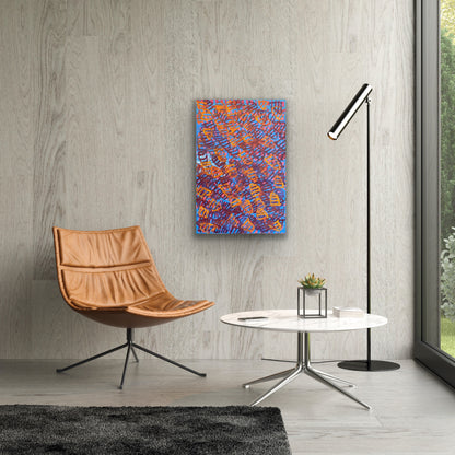 A painting by Emily Pwerle hanging on a wood panelled wall. Modern interior with a brown chair, round table.
