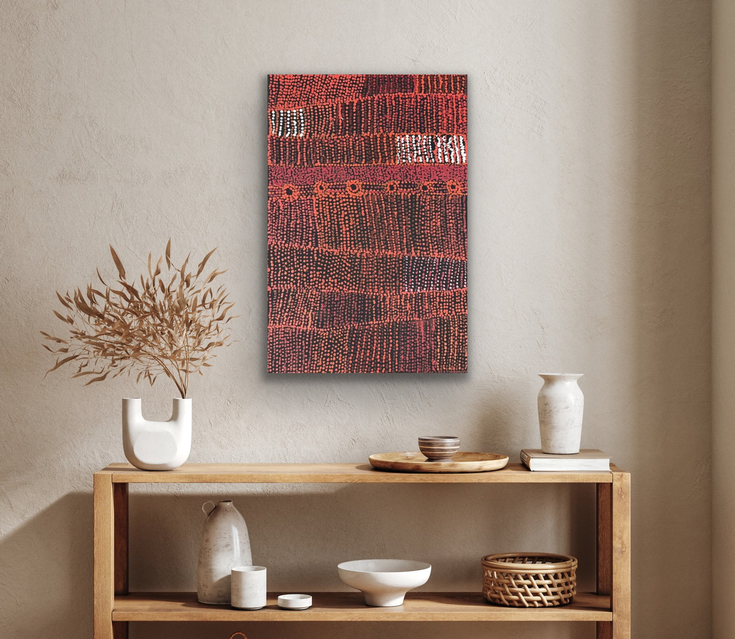 A painting by Maringka Baker on the wall above a wooden shelf with assorted decor items.