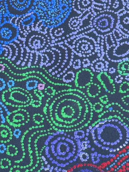 An extreme close-up of a painting by Meredith Curley, featuring intricate dots in blues, greens, purple, pink and red on a primed black canvas.