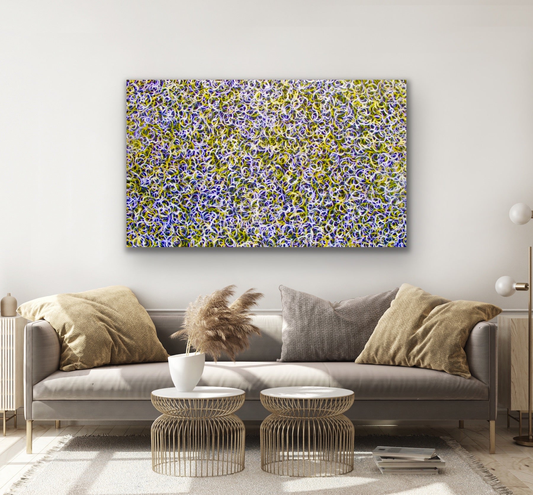 Living room with a gray sofa, decorative pillows, and a coluorful painting by Gloria Petyarre on the wall.