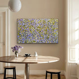 A Mountain Devil Lizard Dreaming painting by Gloria Petyarre on a wall above a wooden table with decor items.