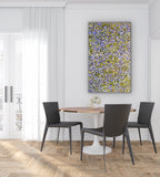 Dining room with a round table and black chairs, featuring a colourful Mountain Devil Lizard Dreaming painting on the wall.