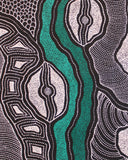 Close-up view of a painting by Delvine Pitjara with two green dotted lines with black and white shapes surrounding 