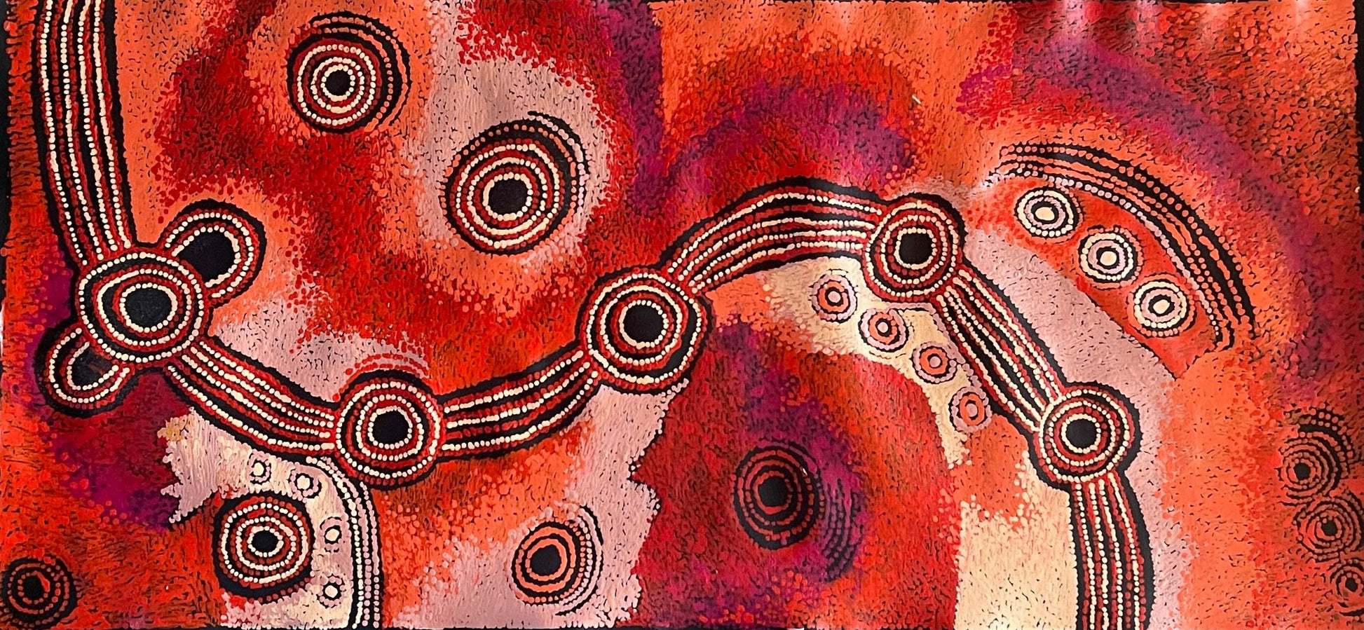 A canvas painting by Teresa Baker featuring abstract geometric patterns with predominantly red and black colors, representing the creation story of Minyma Malilu Tjukurrpa.