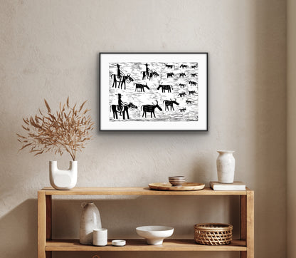 Framed black and white linocut print by Jill Daniels on a wall above a wooden console table with decorative items.