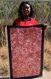 Belinda Golder Kngwarreye holding her 'Bush Plum Dreaming' painting 90x50cm