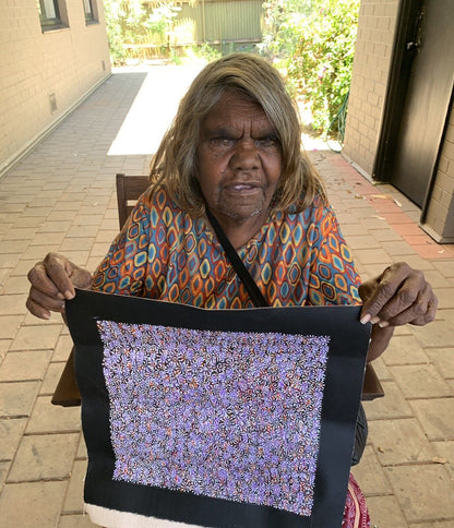 Audrey Morton Kngwarreye holding her Alpitye/Bush Flowers painting 30x30cm