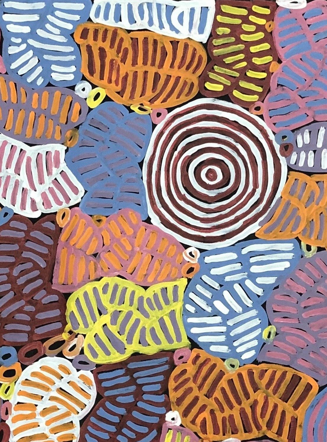 Close-up of a colourful awelye painting by Betty Club Mbitjana featuring various geometric shapes and patterns.