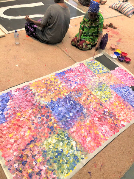 Polly Ngale painting her Bush Plum (Arnwekety) Dreaming painting 110x200cm Multicoloured
