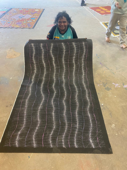 Debbie Brown Napaljarri holding her 'Bush Tomato Dreaming (Wanakiji Jukurrpa)' painting 95x150cm Unstretched White Pink Purple