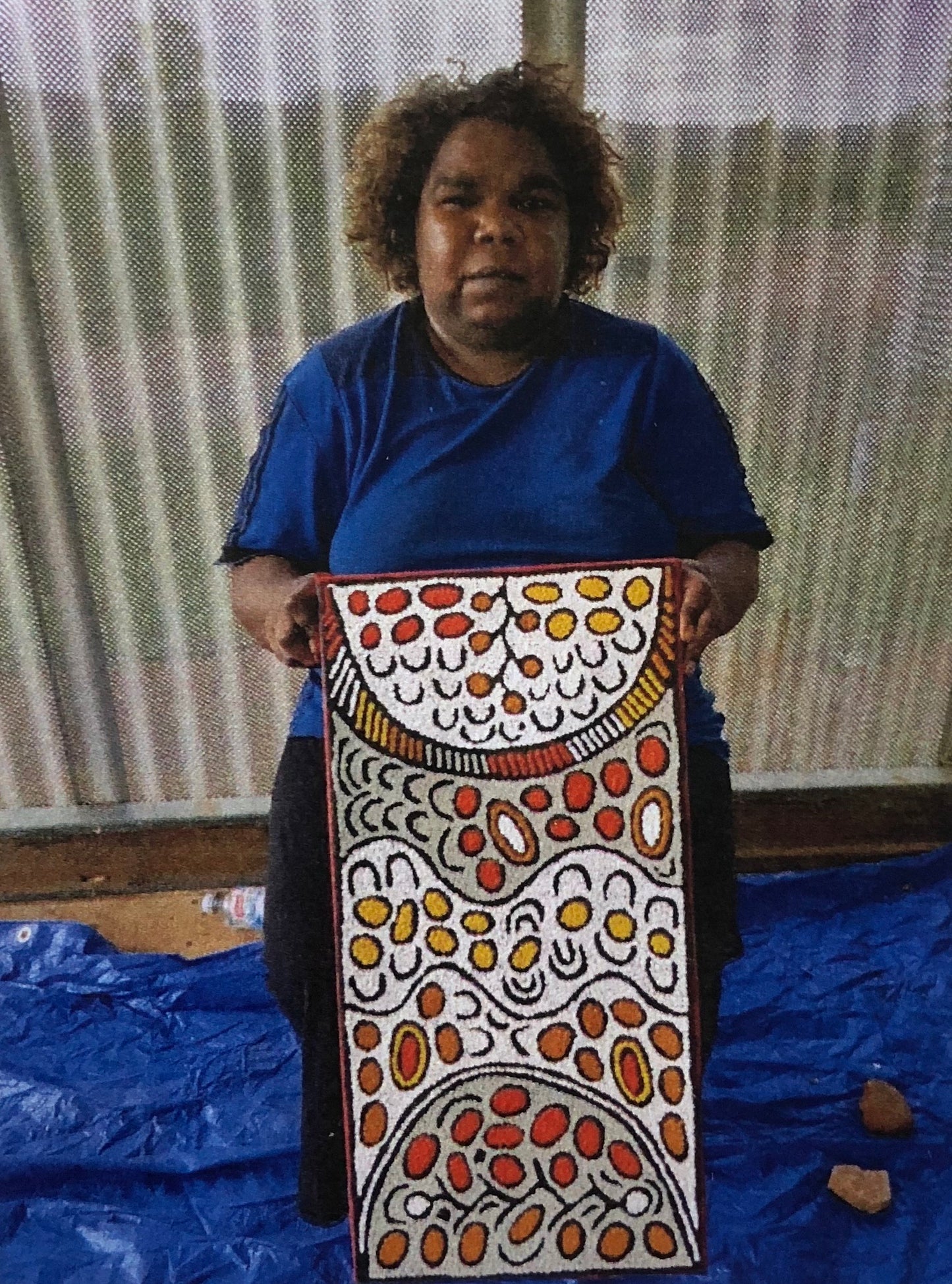 Daphne Larry Nampitjinpa holding her 'My Country' painting 30x60cm
