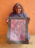 Dulcie Long Pula holding her 'Awelye-Atnwengerrp (Body Paint)' painting 51x36cm Pink Grey White