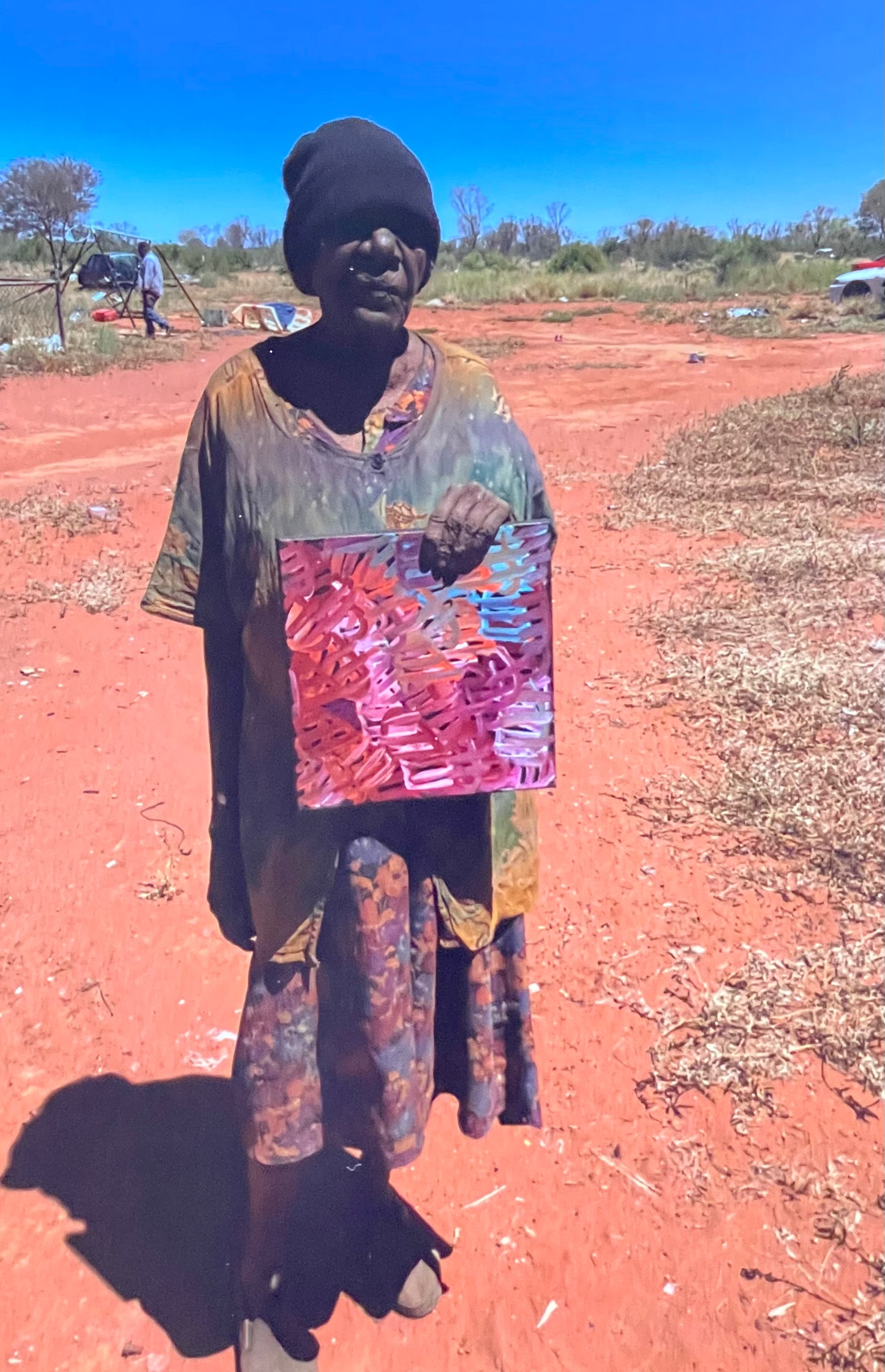 Emily Pwerle holding her 'Awelye (Women's Ceremony) Atnwengerrp' painting 30x30cm Multicoloured