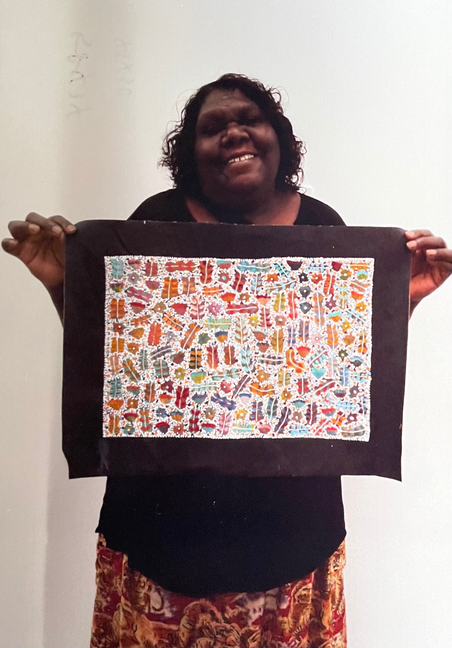 Joycie Morton Petyarre holding her 'Bush Medicine' painting, 30x90cm 