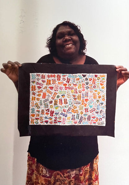 Joycie Morton Petyarre holding her 'Bush Medicine' painting, 30x90cm 