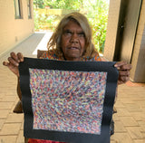 Audrey Morton Kngwarreye holding her Alpitye/Bush Flowers painting 30x30cm