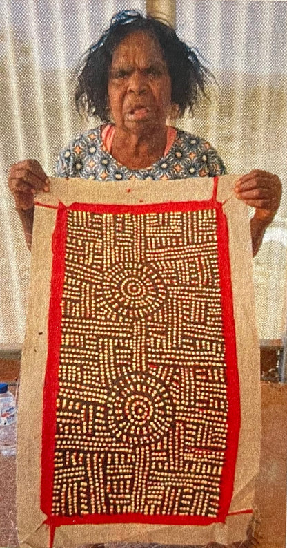 Bambatu Napangardi holding her 'Kungka Tjukurrpa' painting, 30x60cm